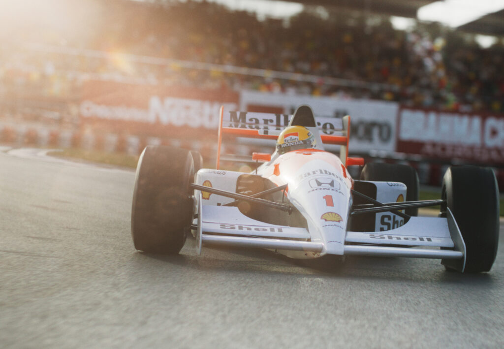 Senna pilotando sua McLaren em algum autódromo, vindo em direção à câmera.