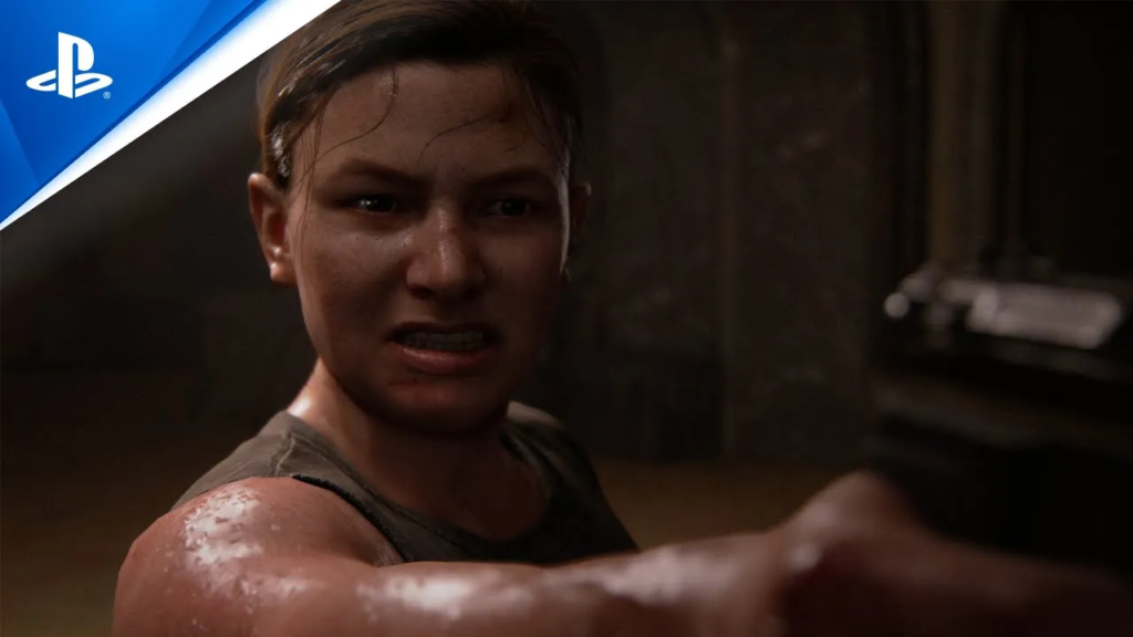 Cena do game The Last of Us: Part II exibindo a personagem Abby, com feição de raiva e apontando uma arma.