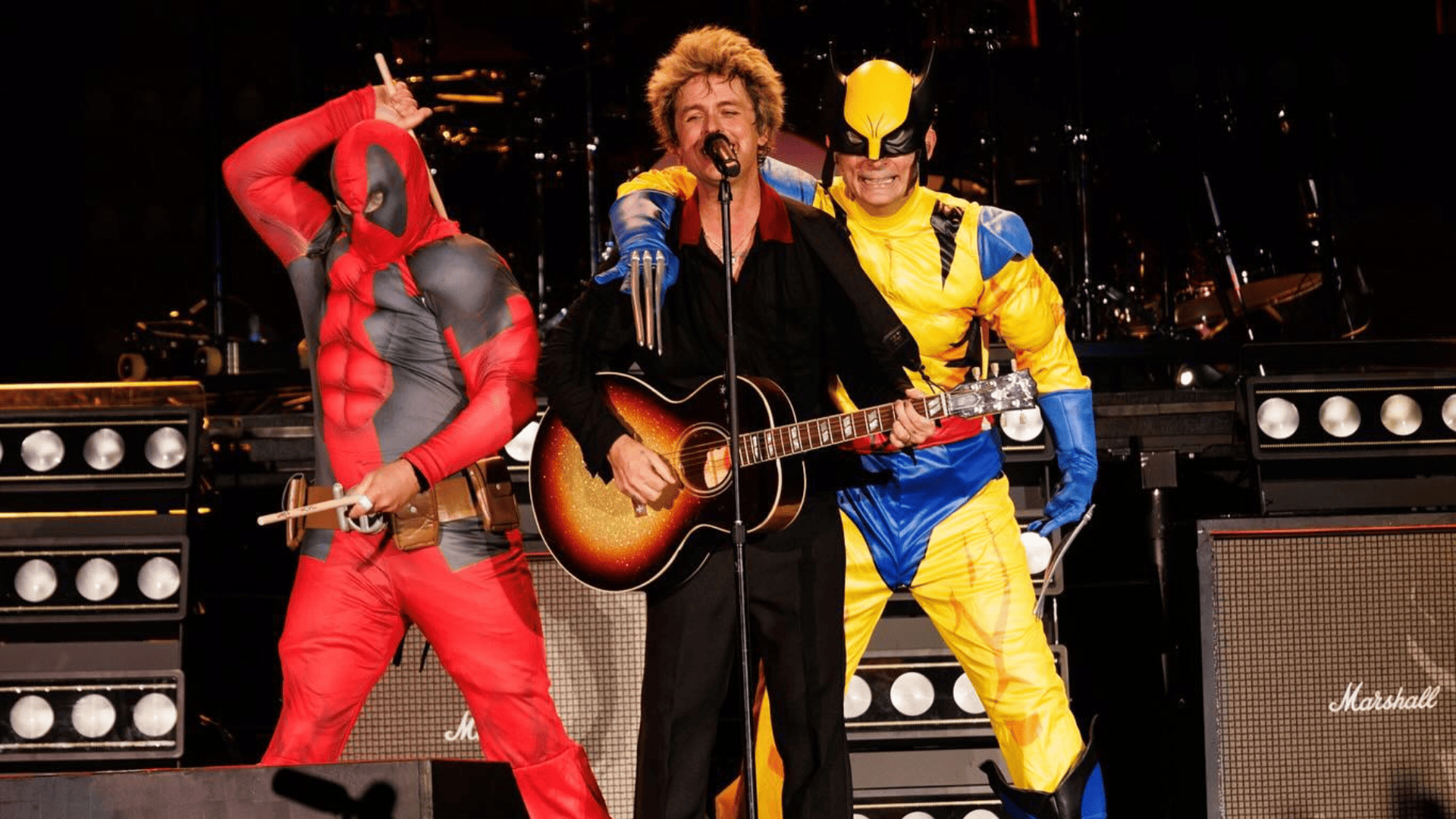 Green Day, durante apresentação. Da esquerda para a direita: Tré Cool (baterista), como Deadpool, Billie Joe (vocalista) e Mike Dirnt (baixista), como Wolverine (Foto: Instagram/Green Day)