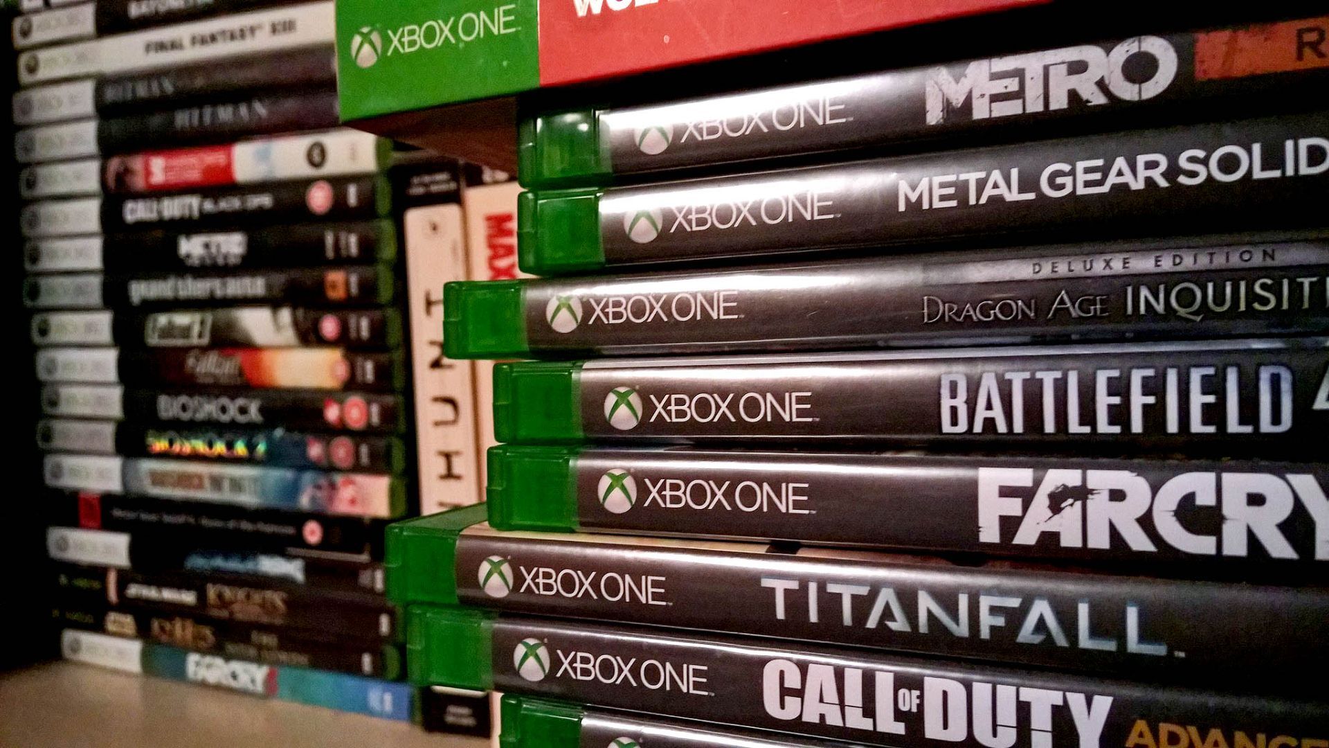 No primeiro plano à direita, mídias físicas de Xbox One. No fundo à esquerda, mídias físicas de Xbox 360.